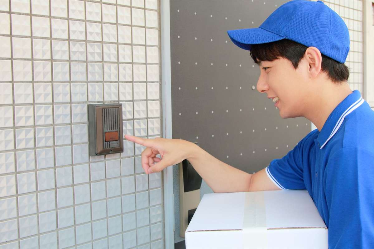 インターホンを押す男性スタッフ-web